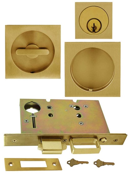 Premium Keyed Pocket-Door Mortise Lock Set with Square Pulls in Aged Brass.